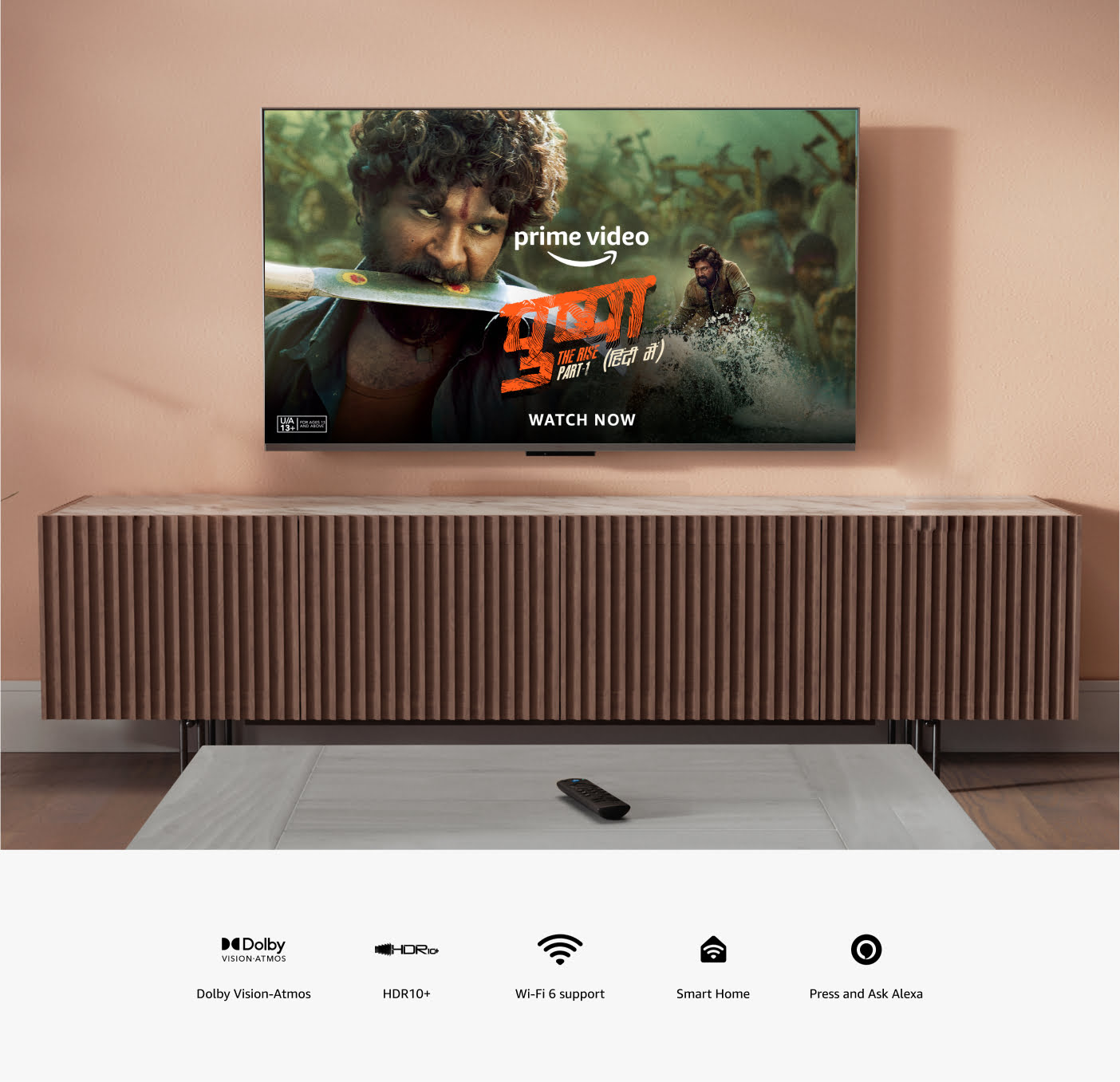 A wall-mounted TV has a remote on the table below. 